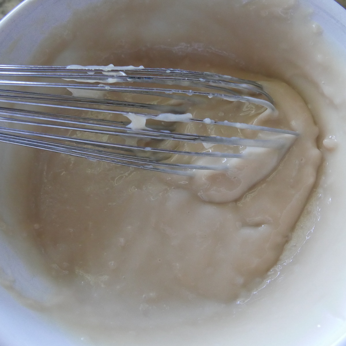 vegan pastry cream being whisked in a bowl.