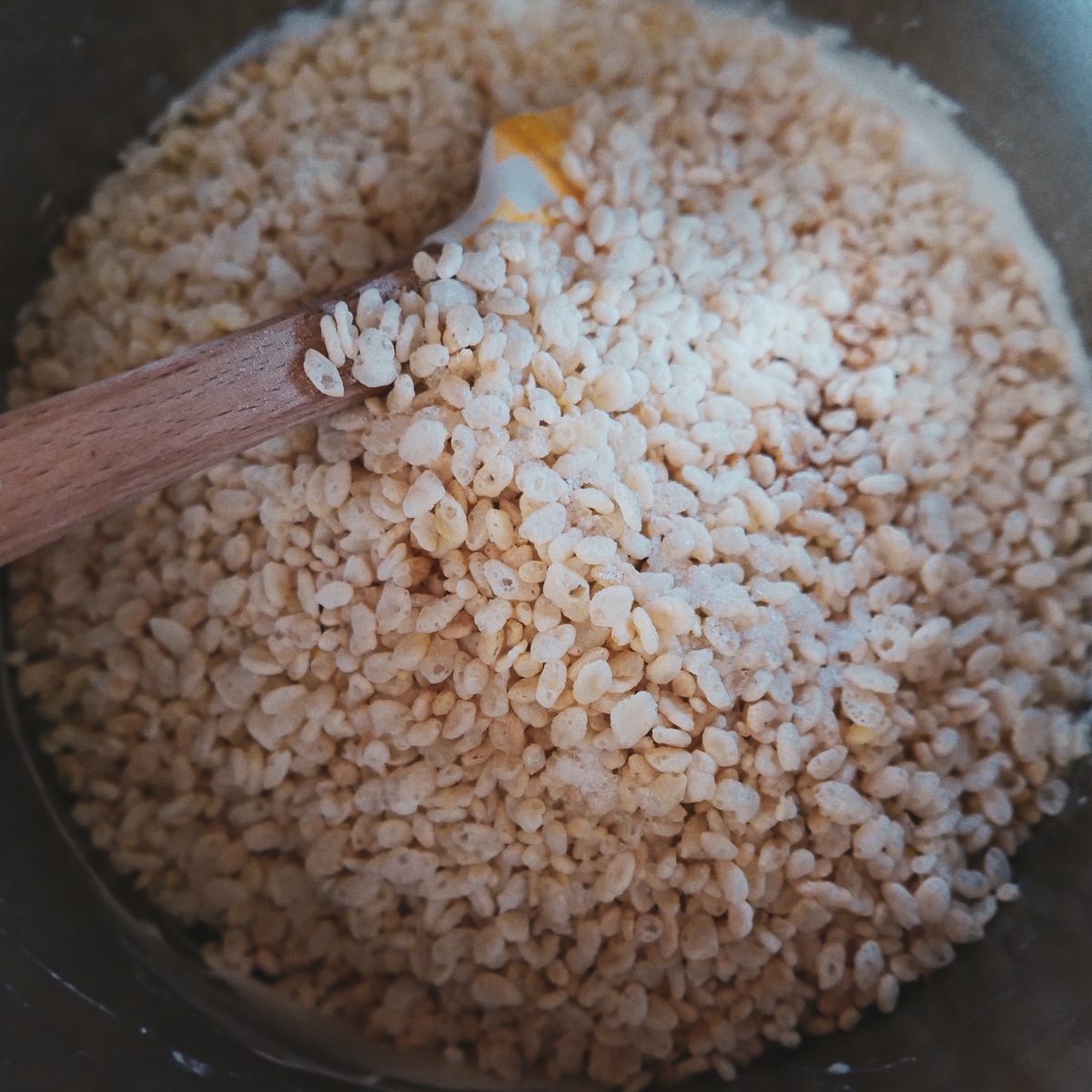 rice krispies being stirred into melted marshmallow mixture.