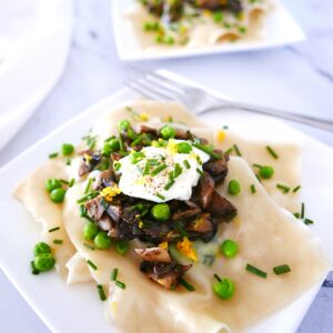 spring pea ravioli with mushrooms on a plate.