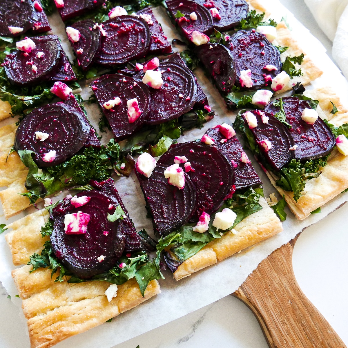 sliced tart on a wooden cutting board.