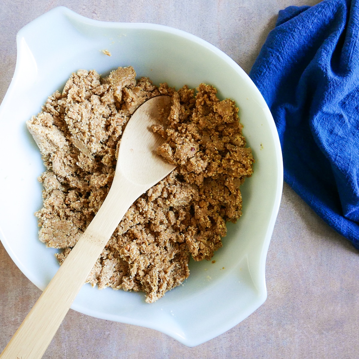 cookie dough mixed in a bowl with wooden spoon.