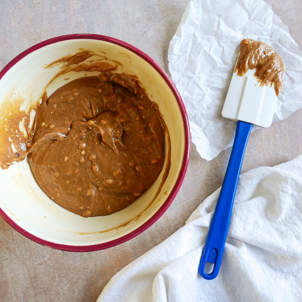 peanut butter, maple syrup, and vanilla mixed in a bowl with rubber spatula.