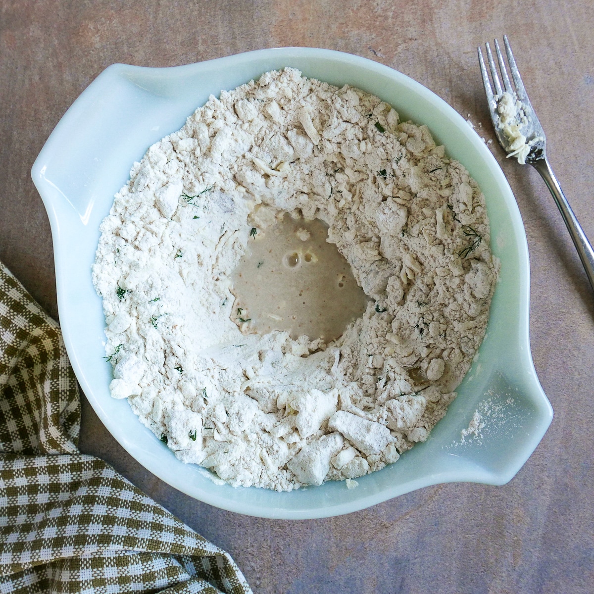 making a well in biscuit dough for buttermilk to be added.