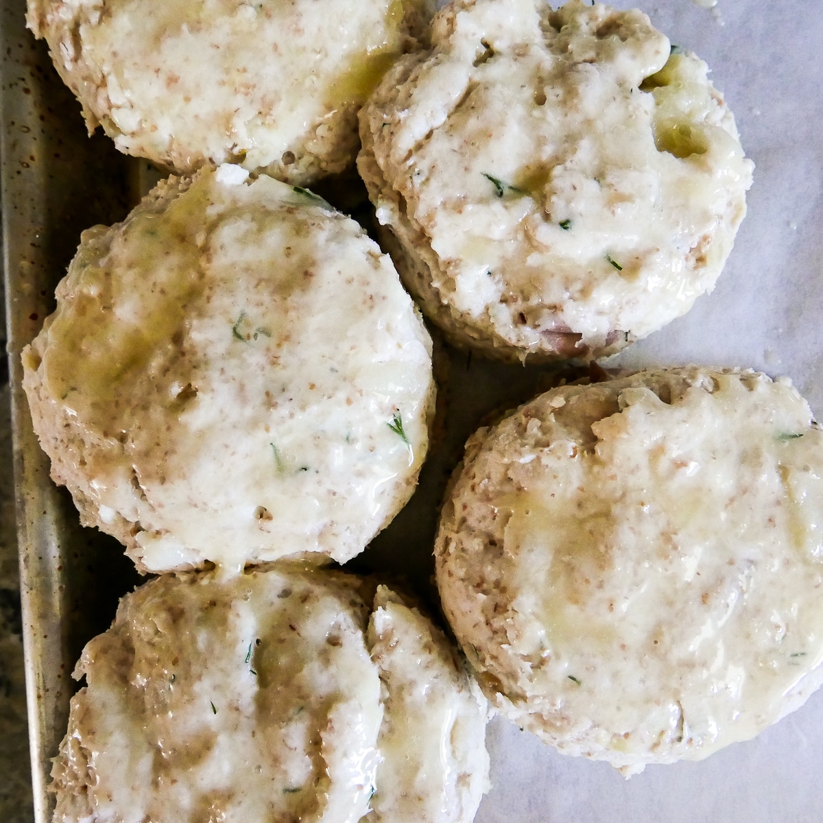 buttered dill biscuits on parchment paper.