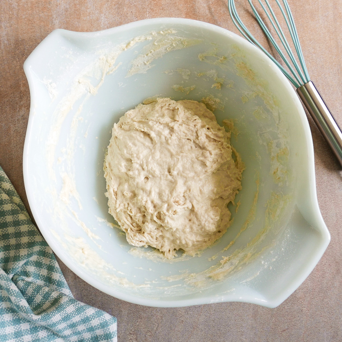 dough-in-mixing-bowl.jpg Dough in a mixing bowl with a whisk and napkin.