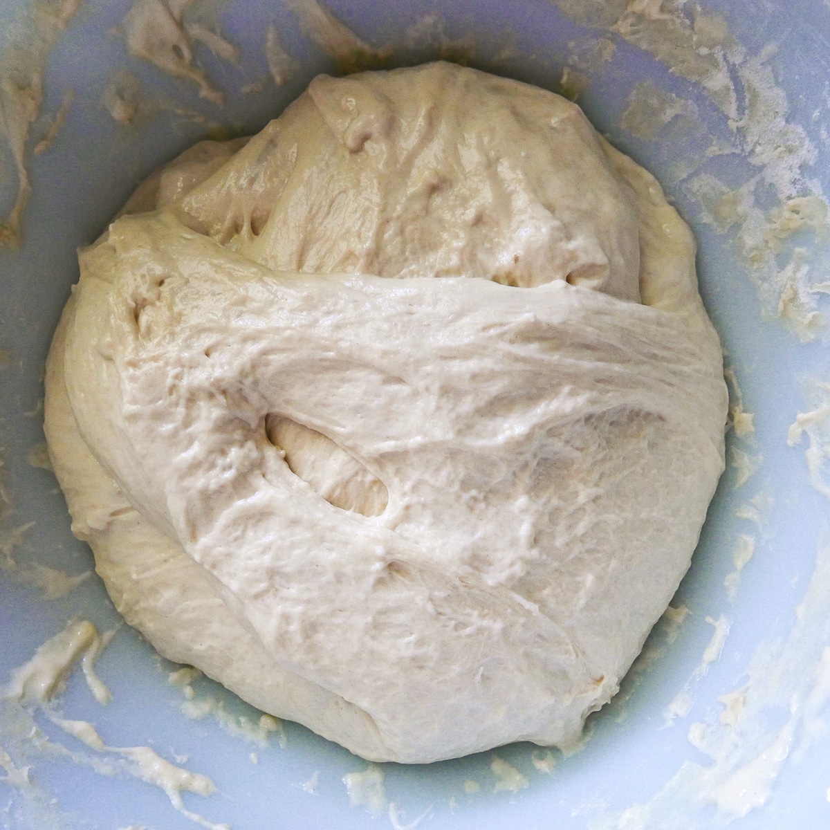 ciabatta roll dough doubled in size and resting in a bowl.