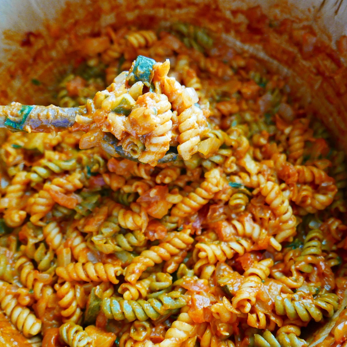 Mascarpone cheese and bail added to pasta mixture cooking in a Dutch oven.