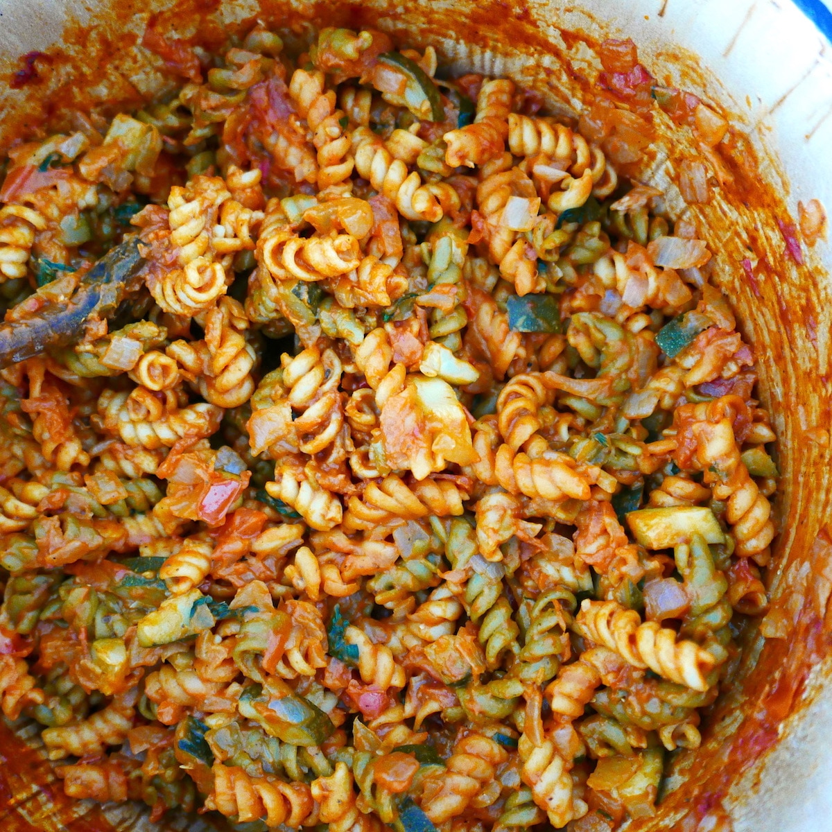 Water and pasta added to pot with cooked onion and zucchini.