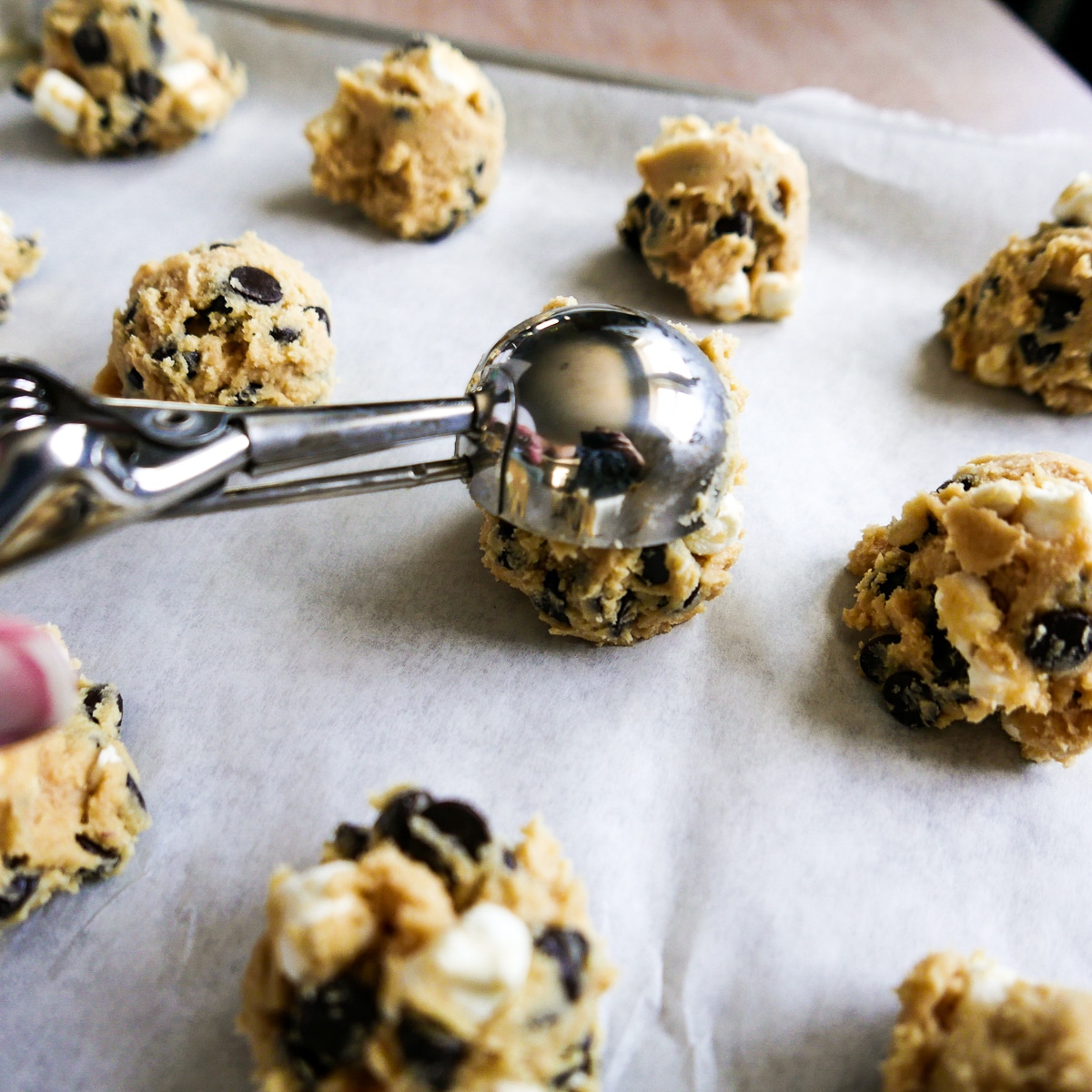 using a cookie scoop to place dough on a baking sheet.