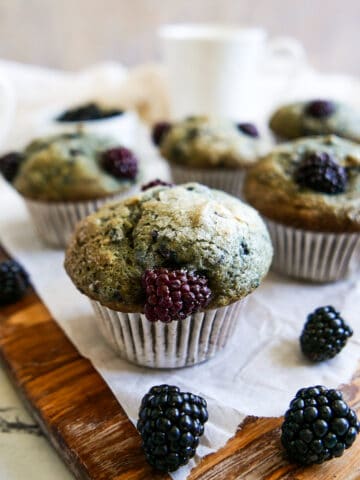 gluten free blackberry muffins arranged on a wooden board.