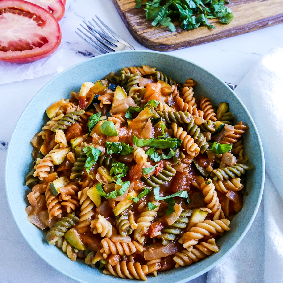 bowl of rotini pasta with mascarpone tomato sauce and fresh basil.