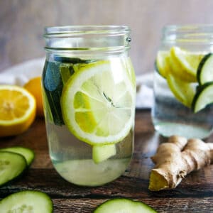 two mason jars with cucumber lemon ginger water.