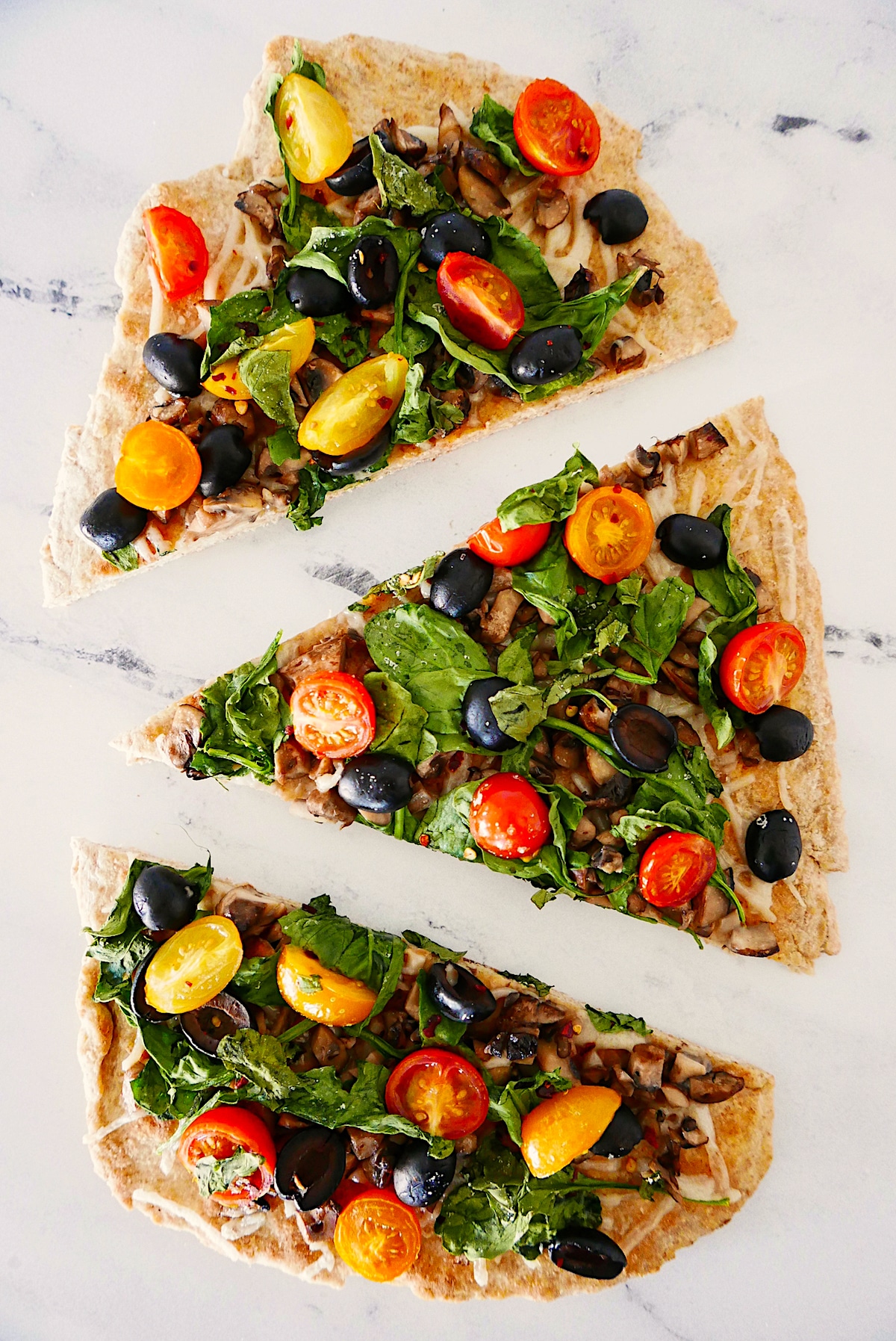 baked dairy free pizza cut into three triangles.