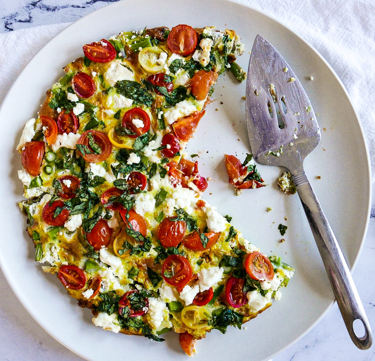 pie-server-with-sliced-frittata.jpg pie server resting on large white platter holding sliced frittata.