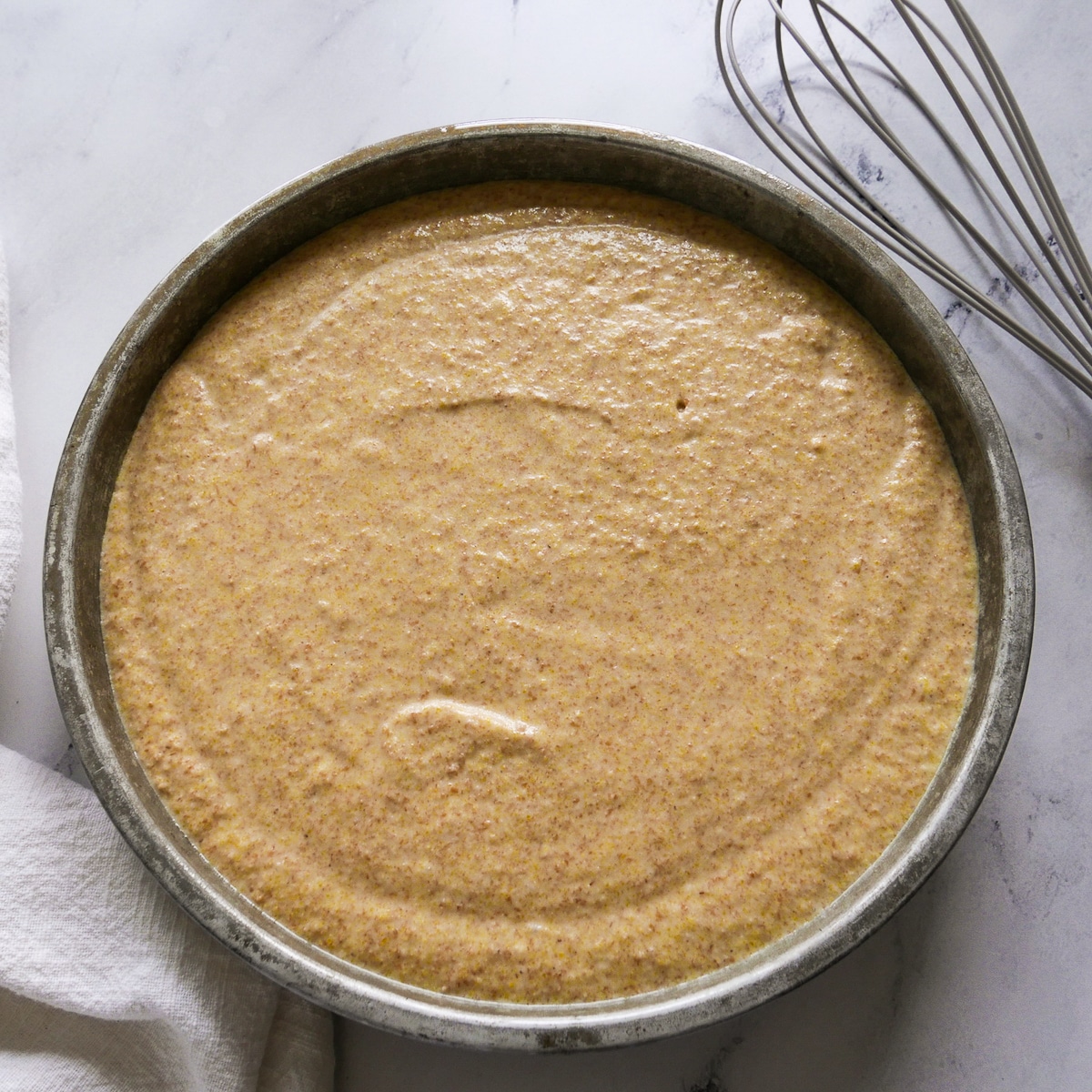 Sourdough cornbread batter poured into prepared round cake pan.