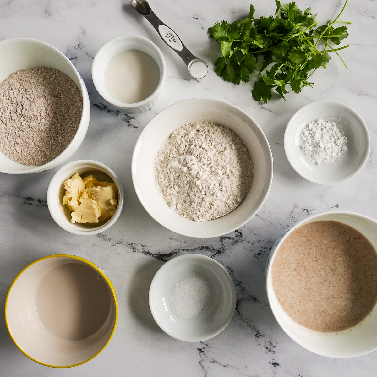 naan ingredients arranged in bowls on a table.