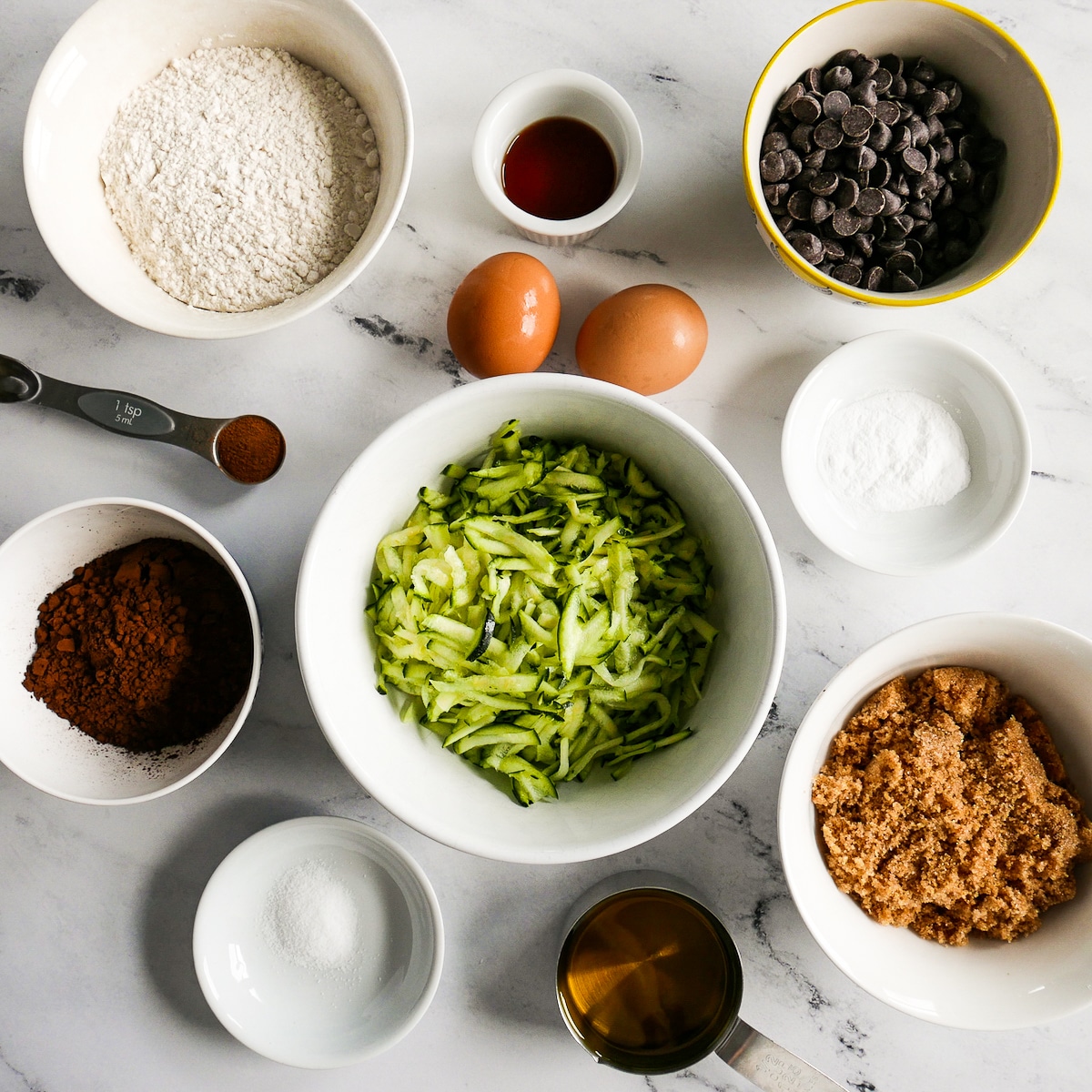 ingredients arranged in bowls and cups on a table.