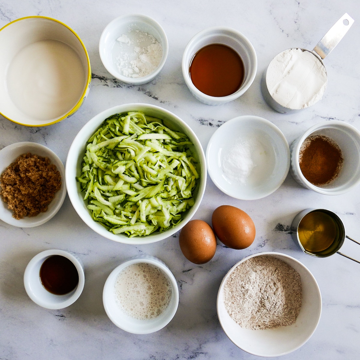 pancake-ingredients.jpg pancake ingredients arranged in cups and bowls on a table.