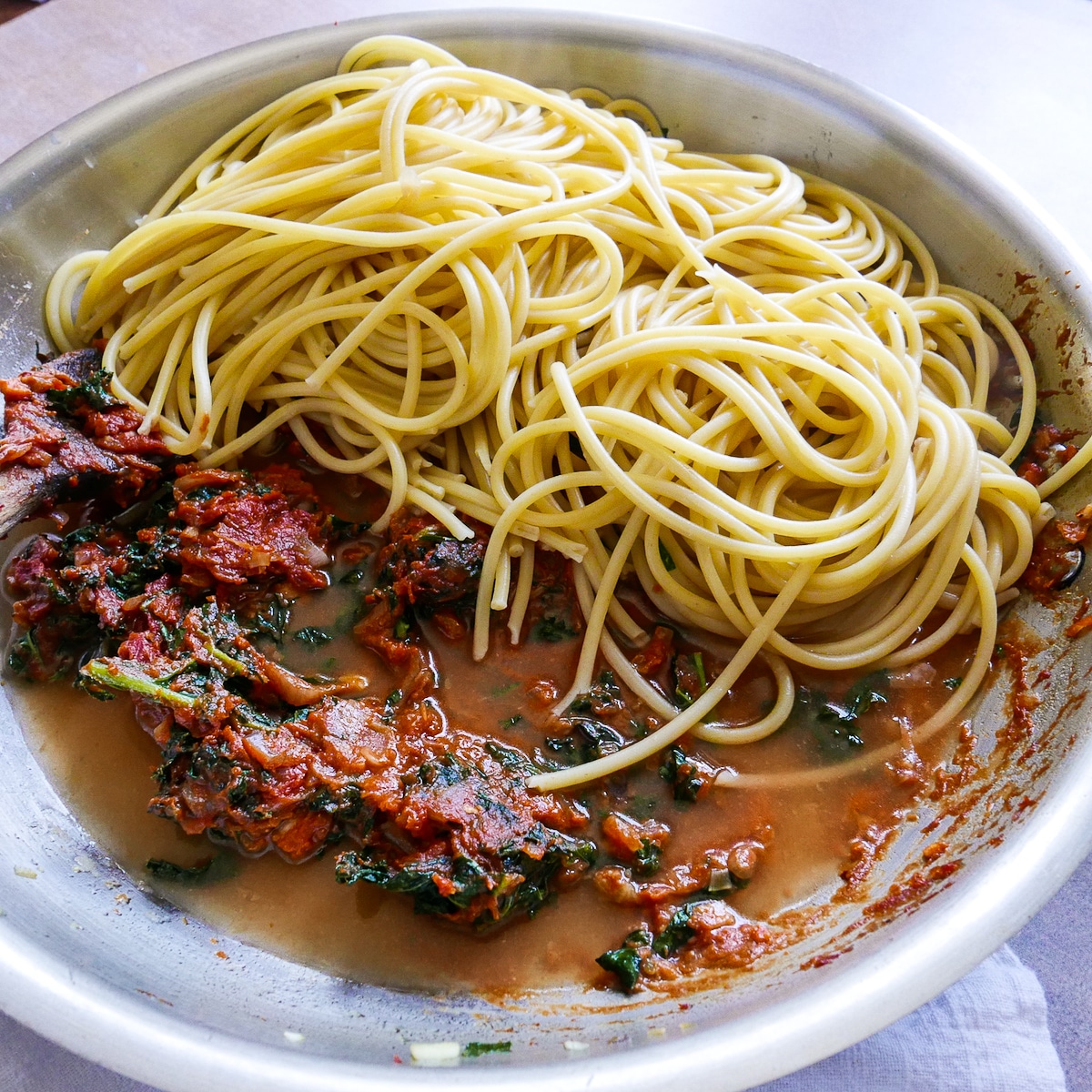 Al dente pasta and pasta water added to shallot mixture in a large skillet.