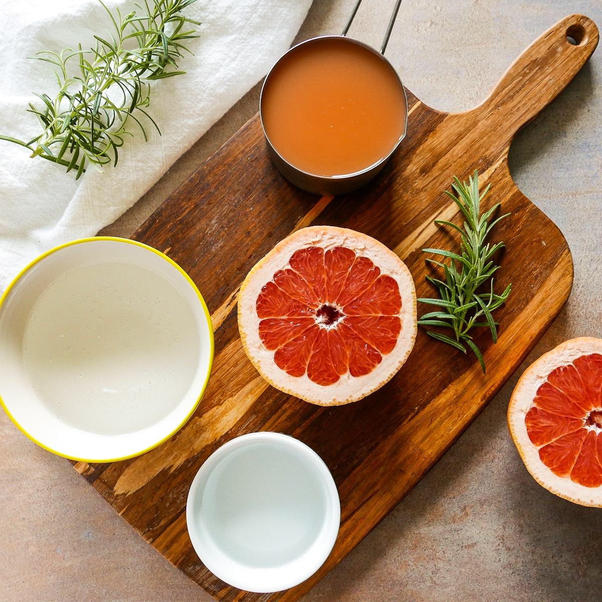 cocktail ingredients arranged on a wooden cutting board.