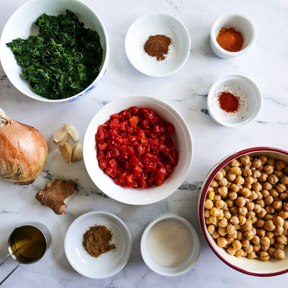 curry ingredients arranged in cups and bowls on a table.