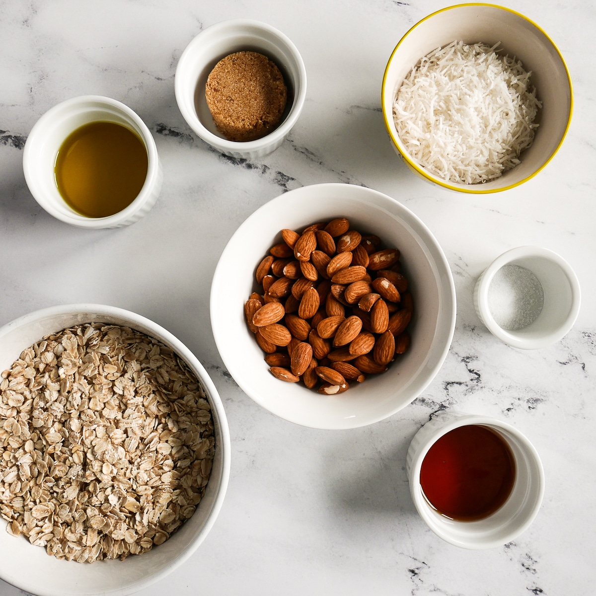 ingredients arranged in a variety of bowls and cups on a table.