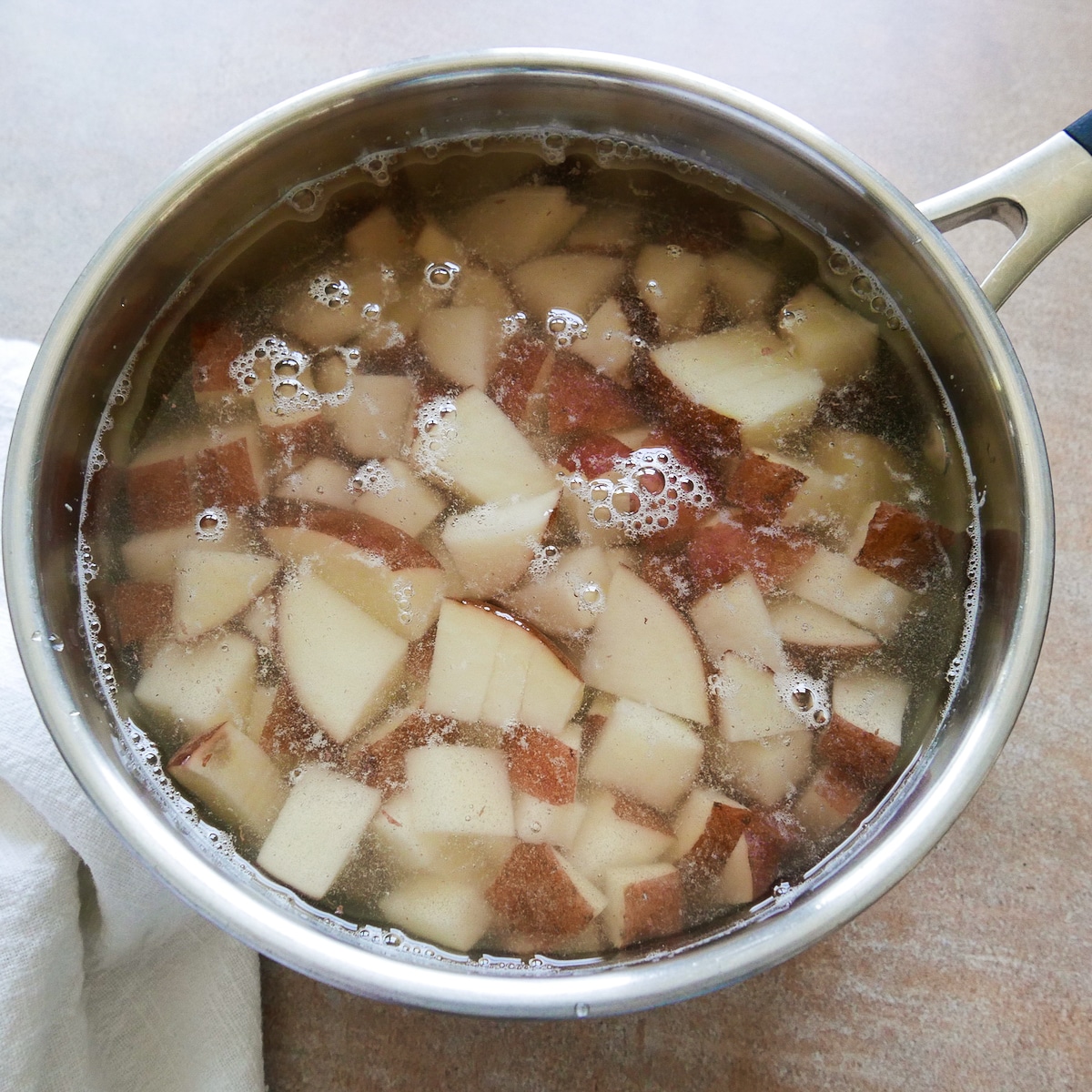 Cut potatoes in a large saucepan covered with water.