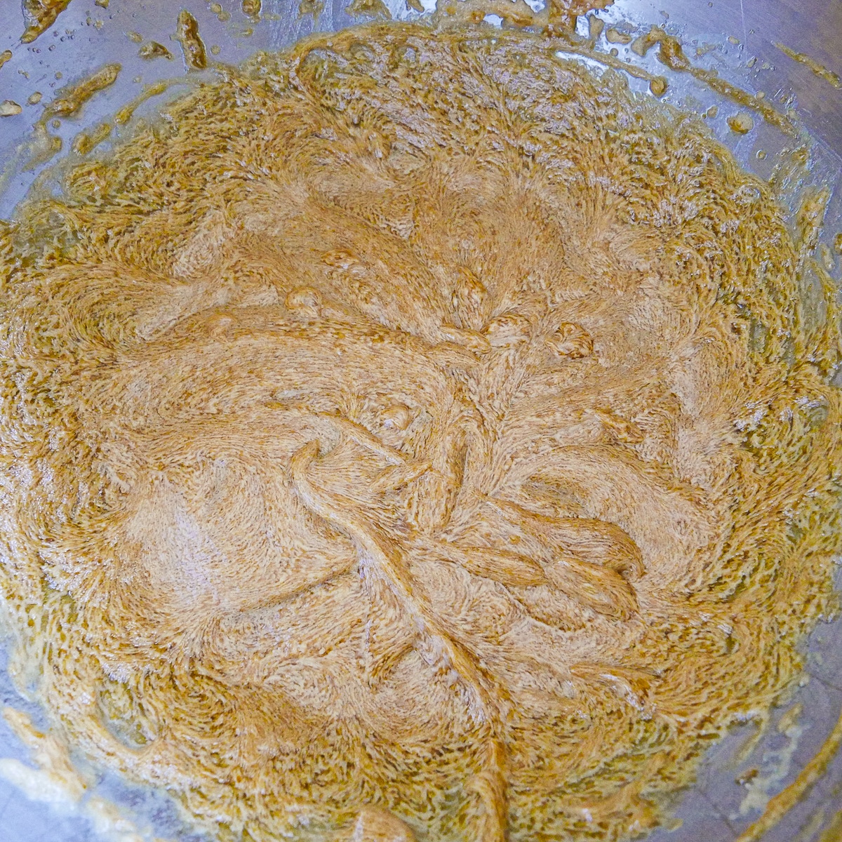molasses, almond milk, and pumpkin puree added to cookie dough mixture in a bowl.