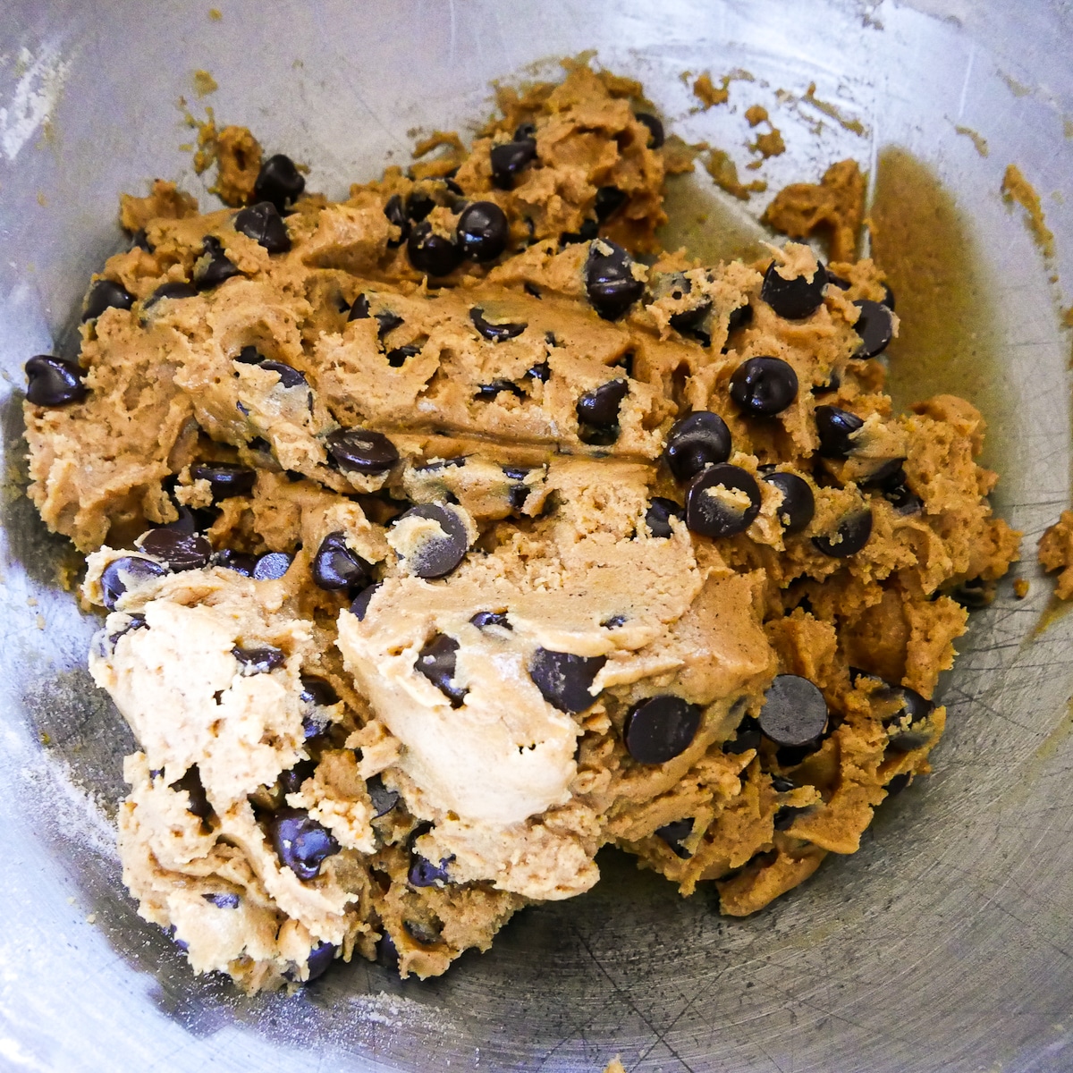 Cookie dough in a plastic wrap covered bowl.