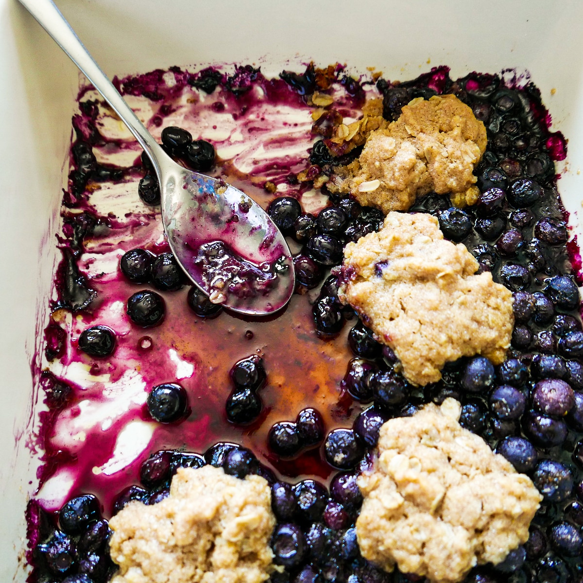 rustic cobbler in a baking dish with a spoon.