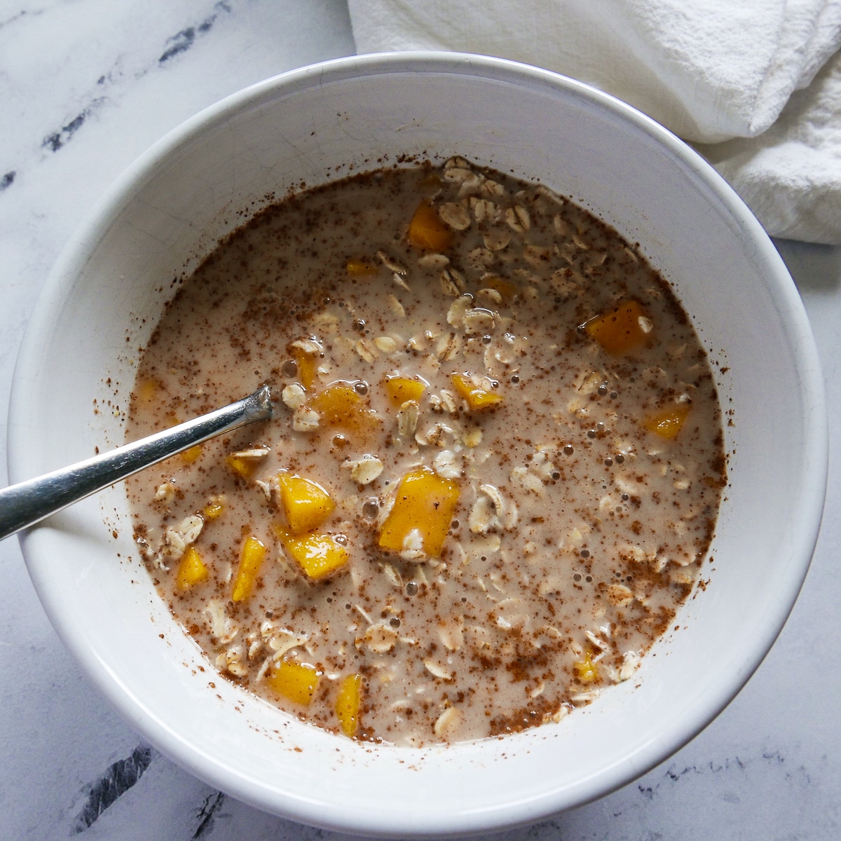 Ingredients combined in a mixing bowl with a large spoon.  