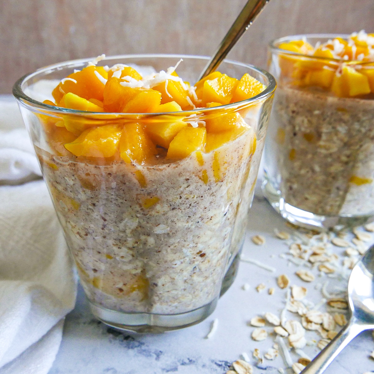 glass of overnight oats with a spoon and white napkin. 