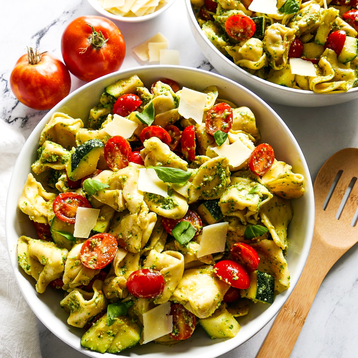 two bowls of vegetarian pasta salad with fresh basil. 