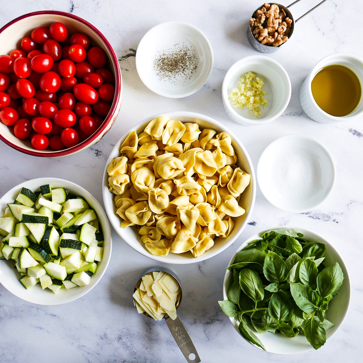 tortellini salad ingredients arranged on a table.
