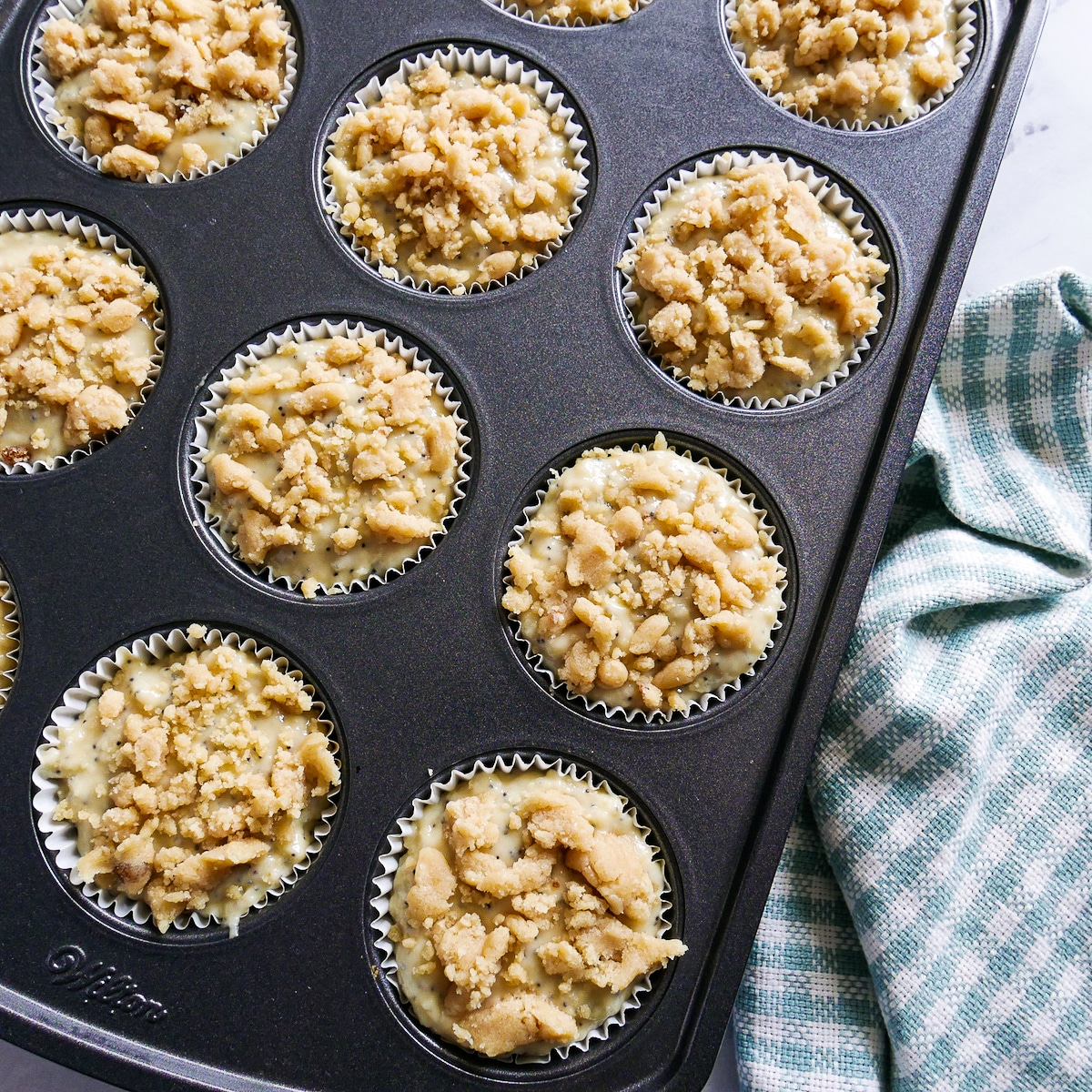 muffin-batter-in-tin.jpg Muffin batter scooped into muffin tin and topped with streusel.