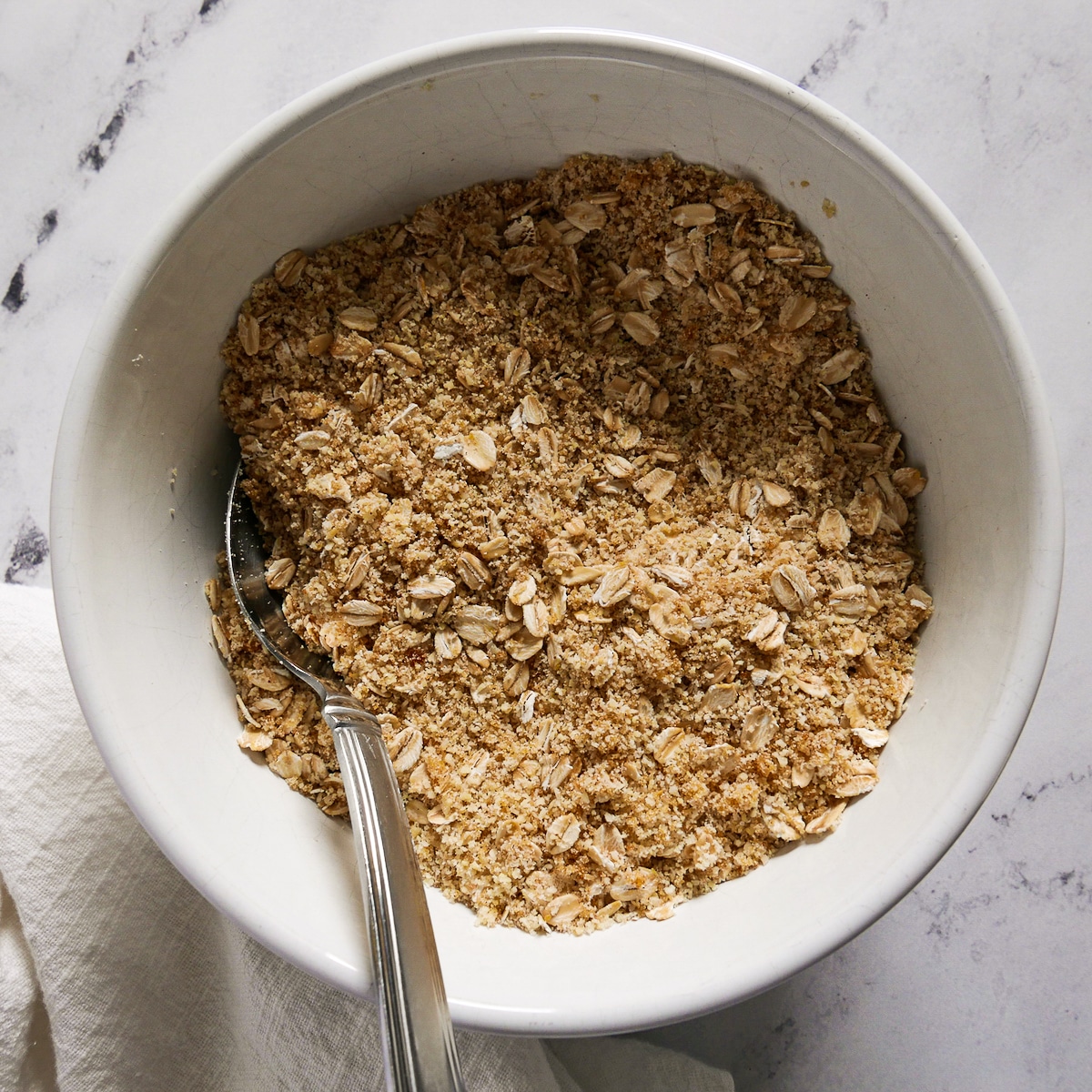 oats, almond flour, and brown sugar whisked in a bowl.