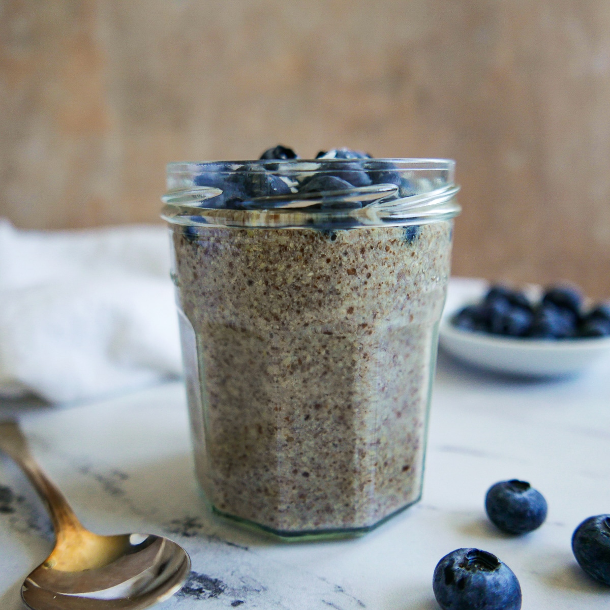 glass-of-pudding.jpg Glass of flax pudding with a spoon and blueberries.