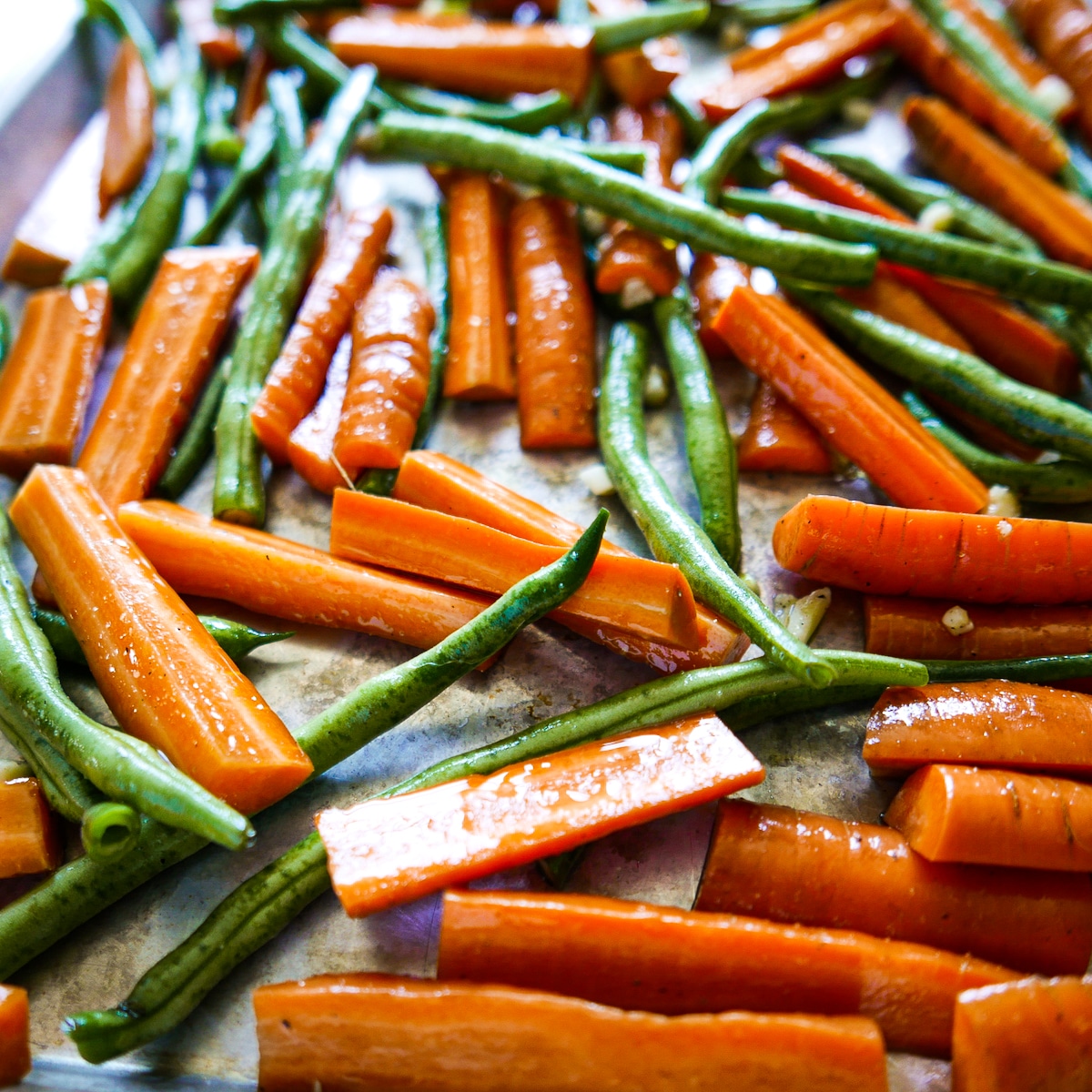tossed-vegetables-in-bowl.jpg cut vegetables tossed with olive oil, garlic, salt, and pepper in a mixing bowl.