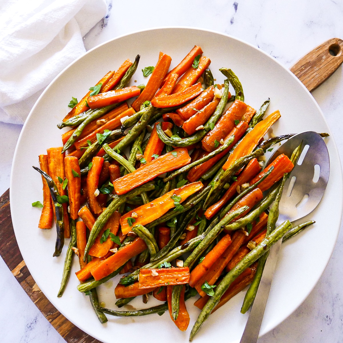 Vegetables on a platter with a serving spoon.