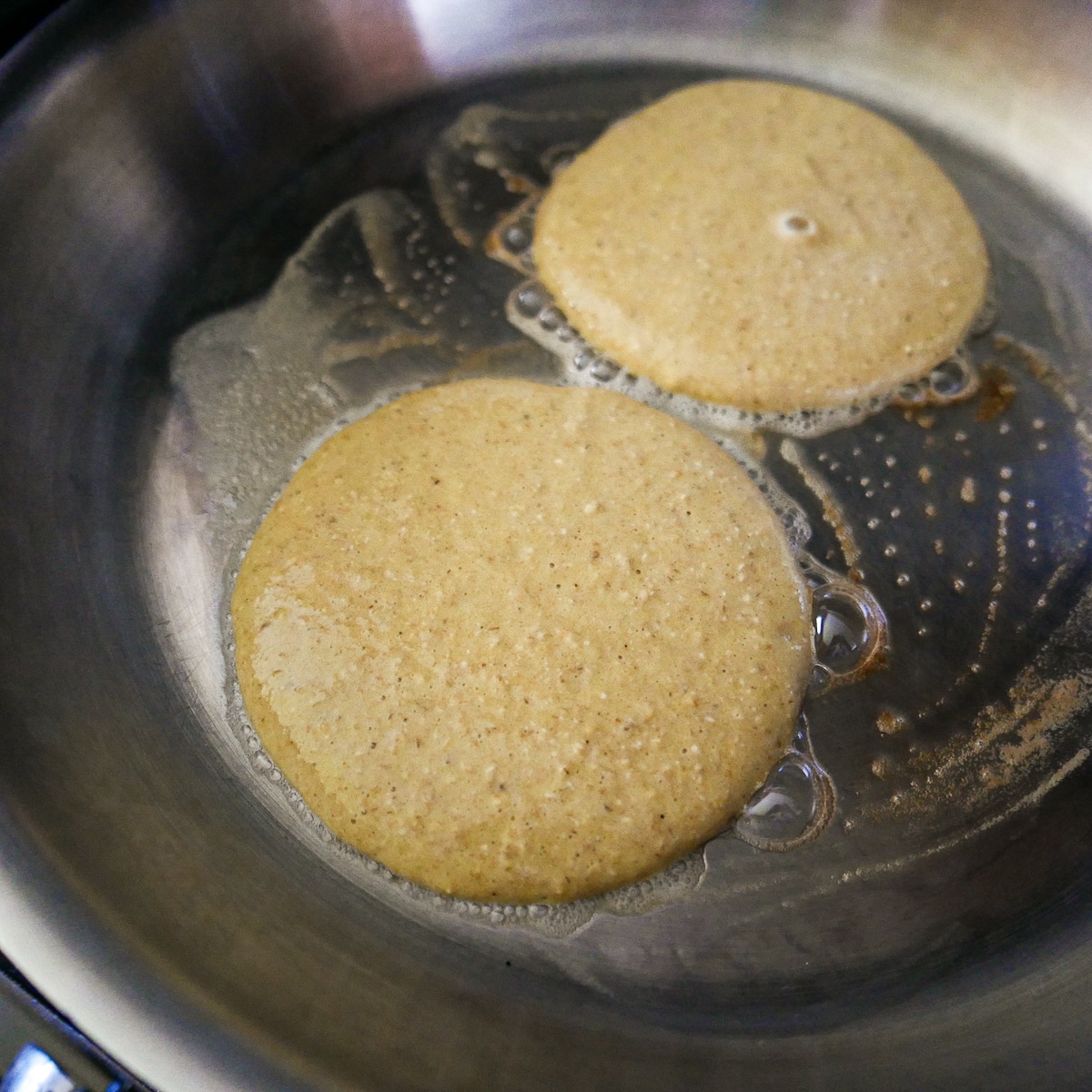 pancakes-cooking-in-pan.jpg pancakes cooking in a non-stick pan.