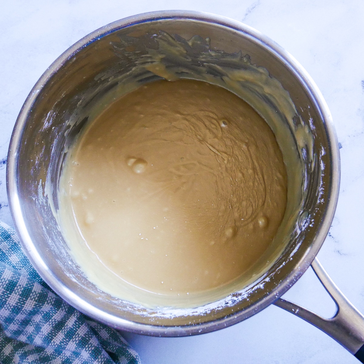 Cooked caramel frosting in a saucepan.