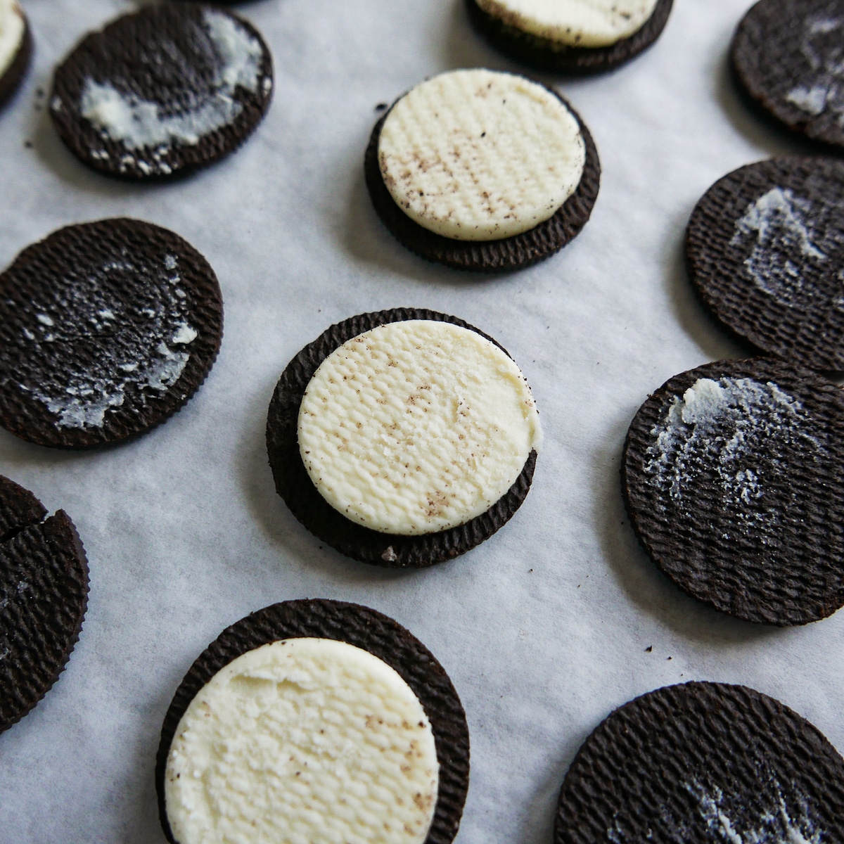 oreos pulled apart and placed on a parchment-lined baking sheet.