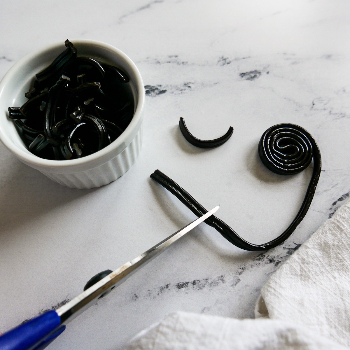 cutting black licorice with a pair of scissors.