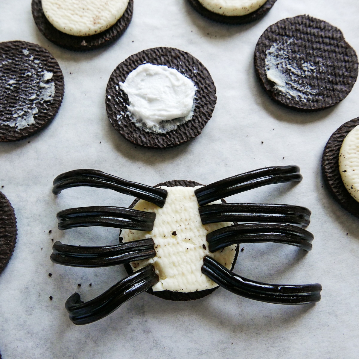 licorice placed onto one side of cookie and icing placed on other piece of cookie.