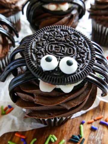 spider oreo cookie placed on a chocolate cupcake.