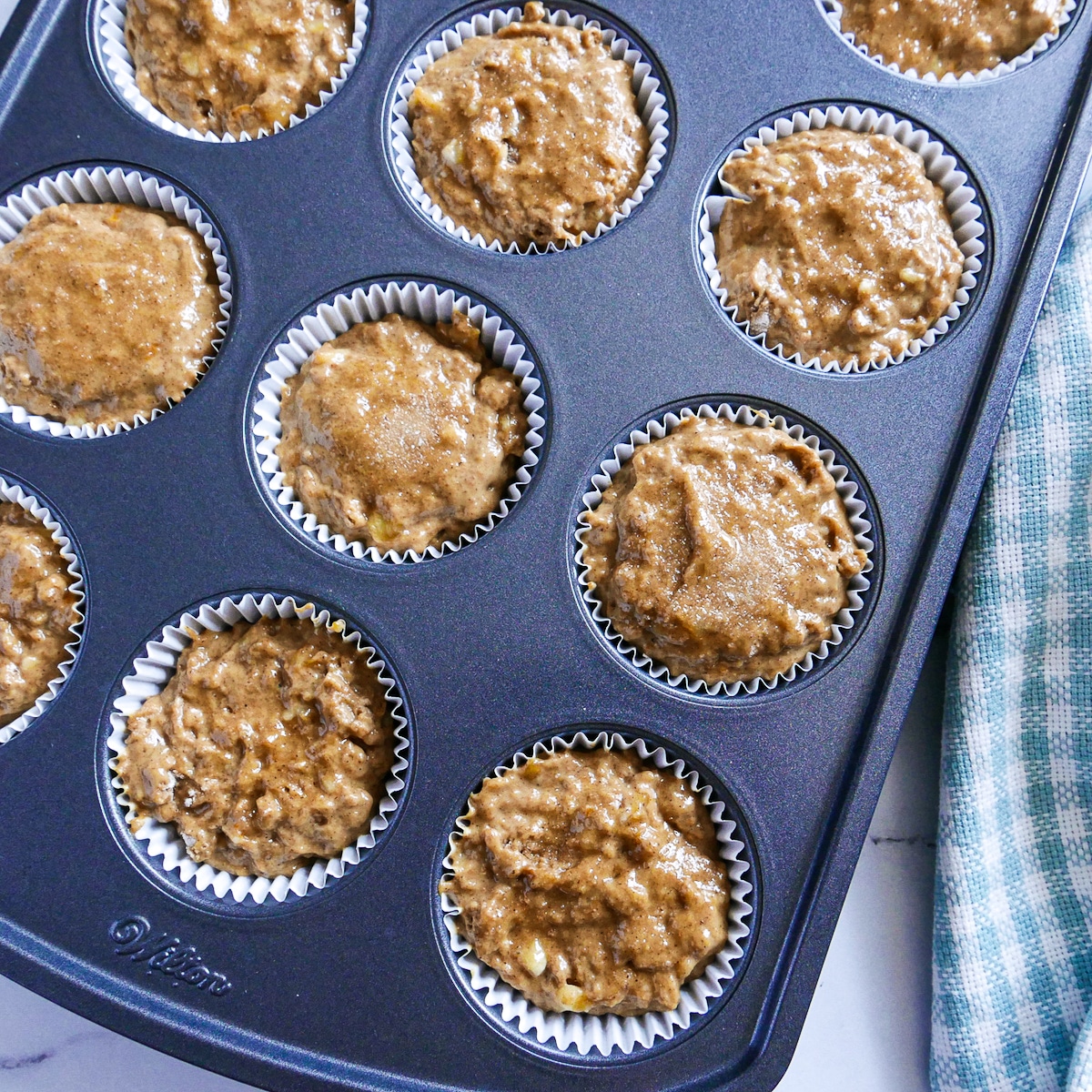 muffin batter in tin with a napkin.