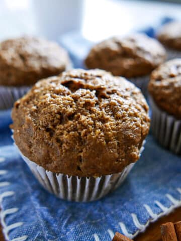 banana gingerbread muffins arranged on a blue dish cloth.