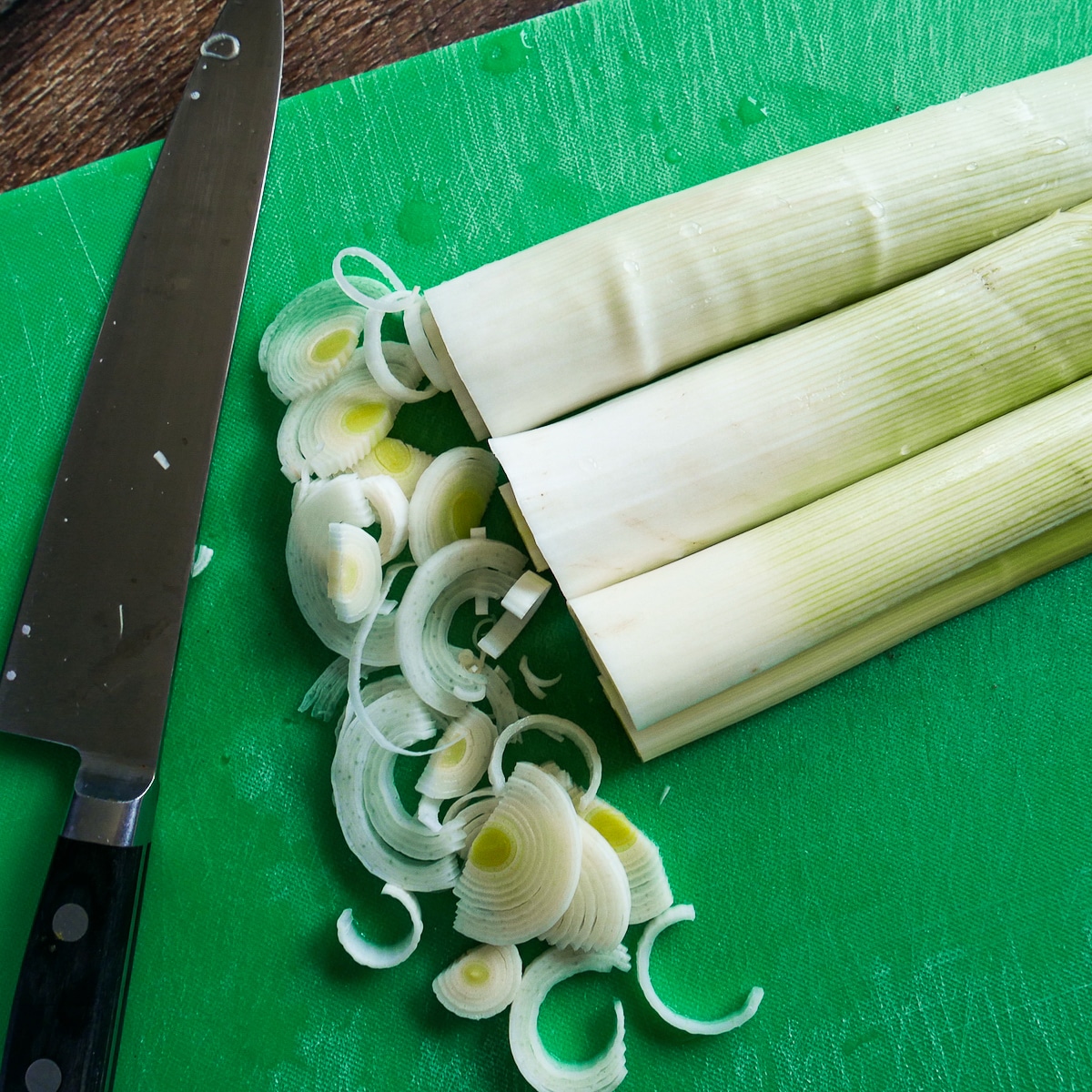 leeks-being-sliced.jpg leeks being sliced on a green cutting board.