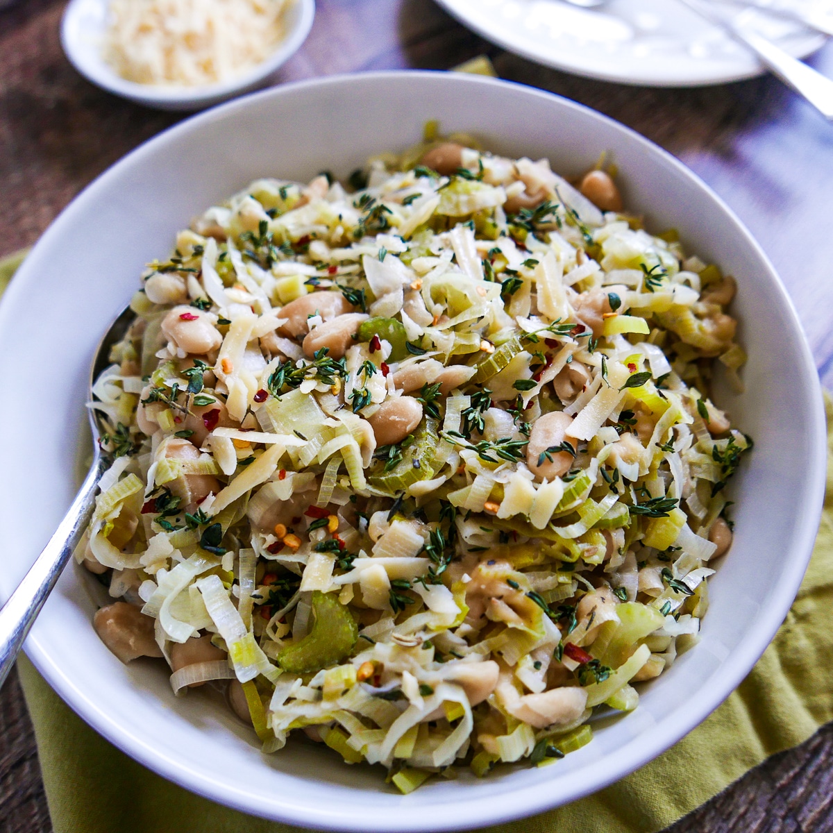 large bowl of white beans and leeks with fresh thyme.