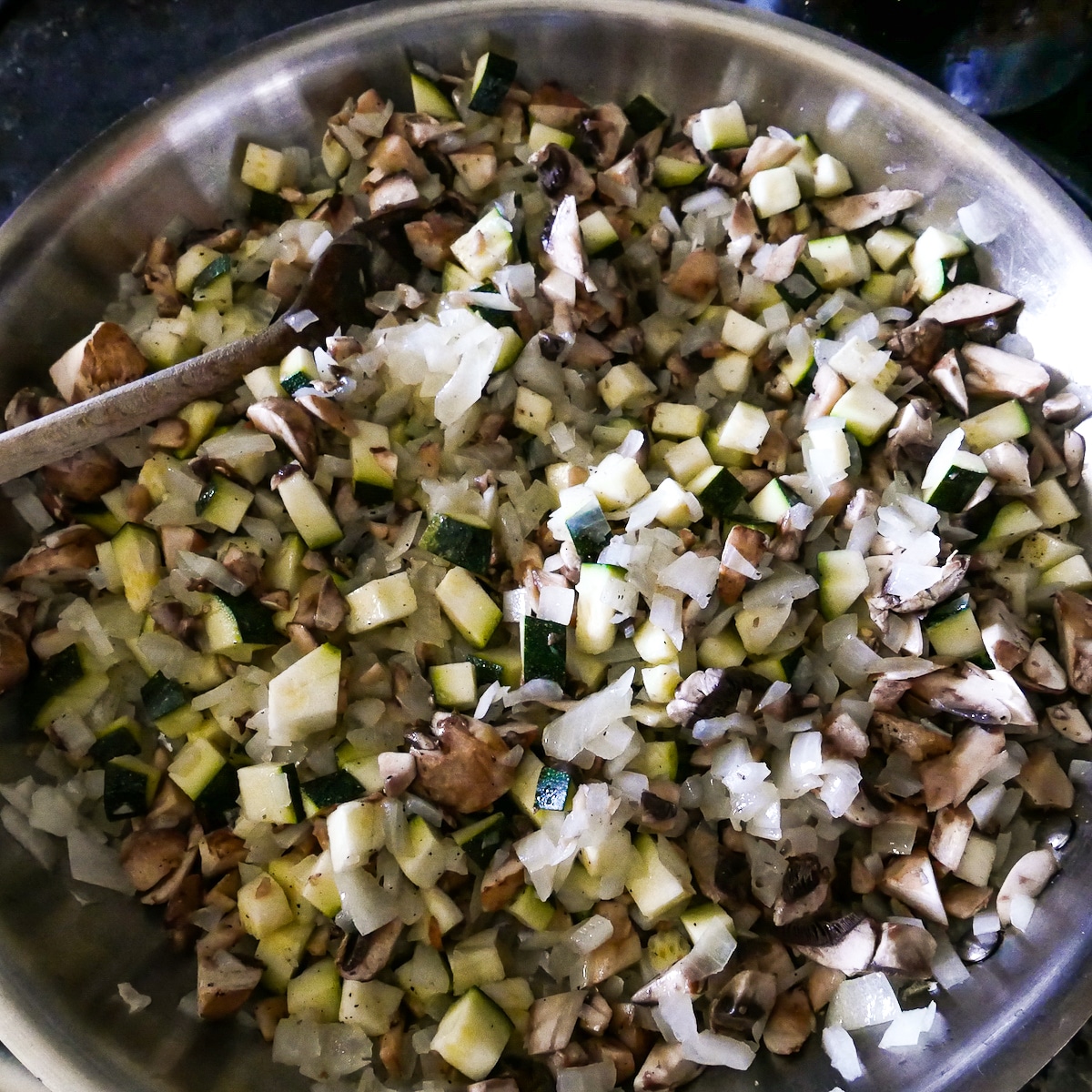 vegetables-cooking-in-skillet.jpg onion, mushrooms, and zucchini cooking in a large skillet.